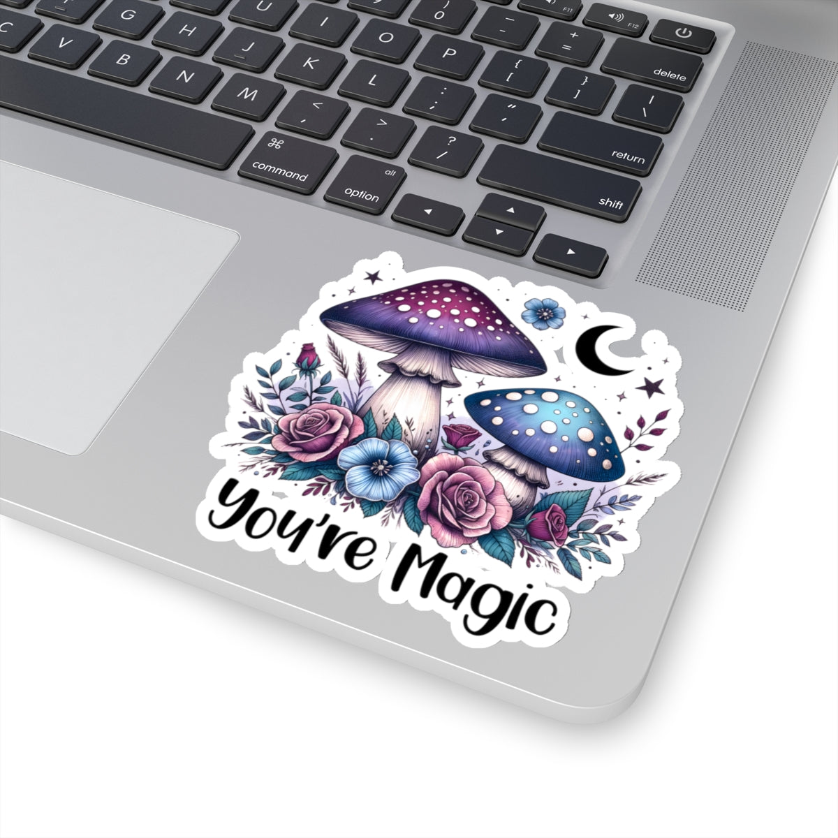 a sticker on a laptop with images of flowers mushrooms and a moon that says you're magic